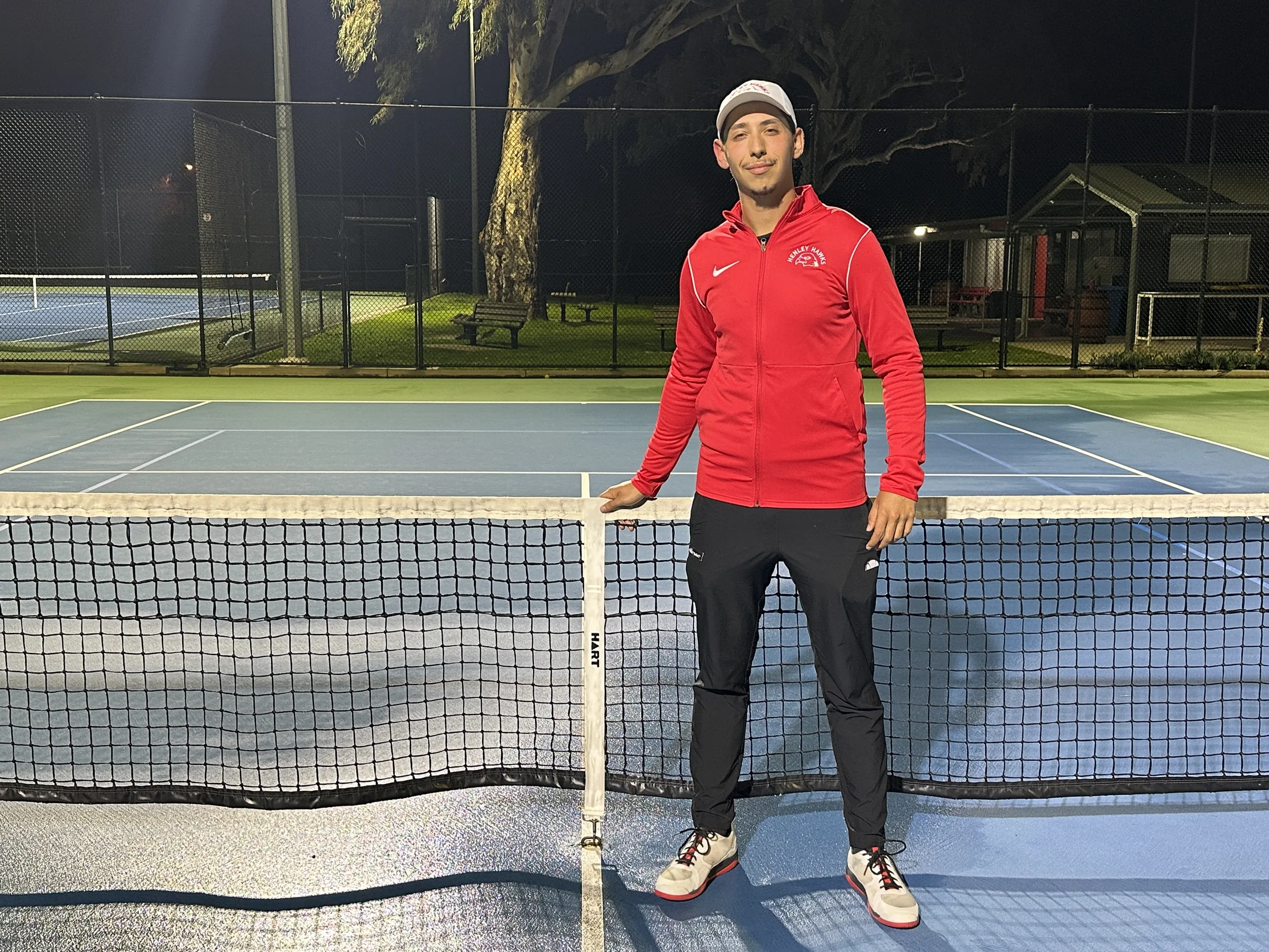 Vera Tennis coach on court at night